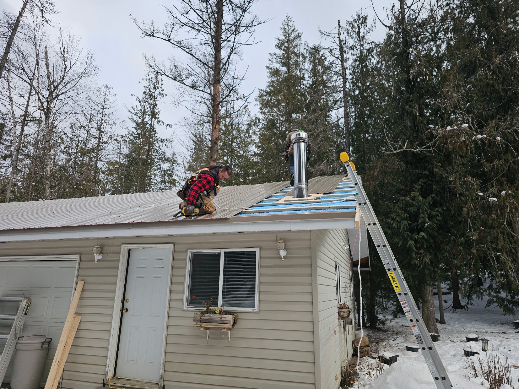 Crew installing metal roofing on a Central Okanagan home