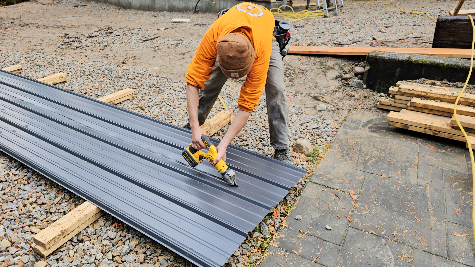 Farrow Built worker cutting metal roofing panels